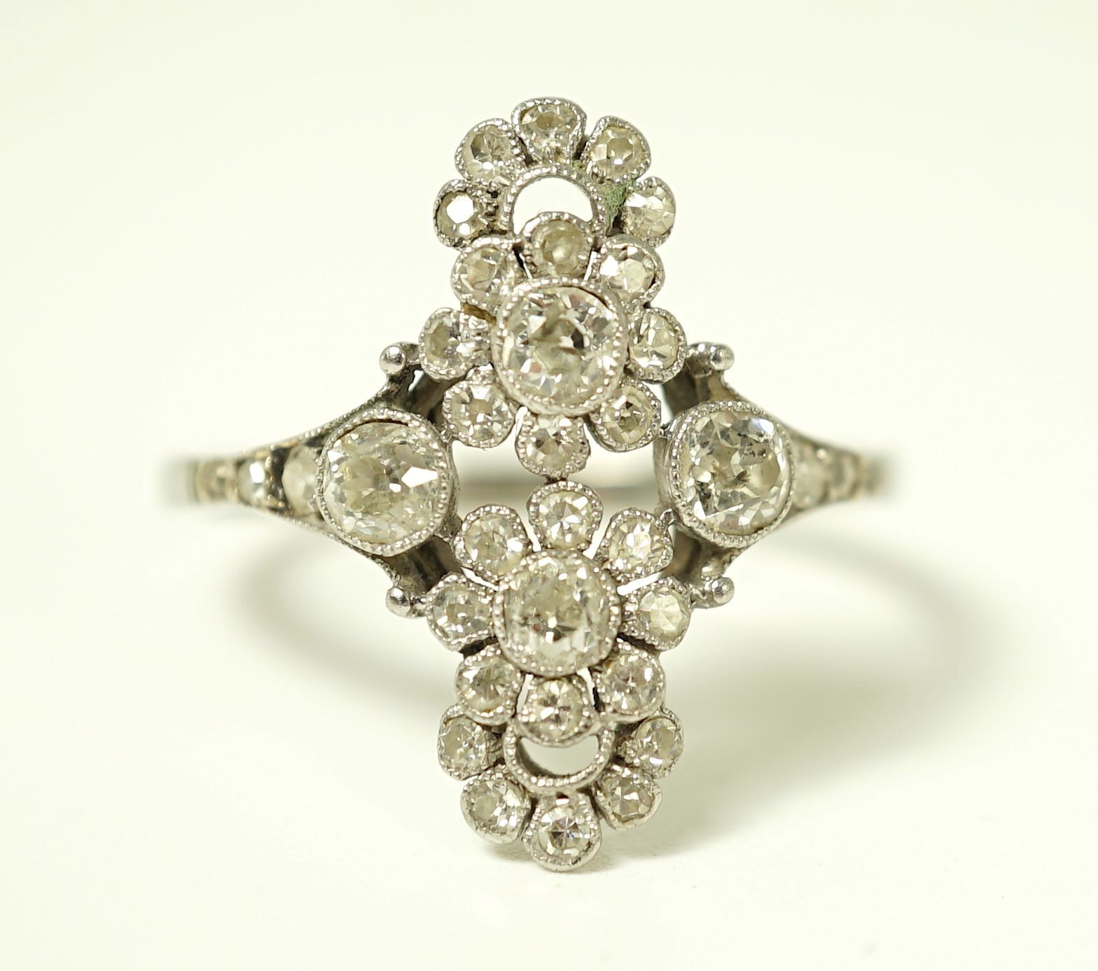 A 1920's platinum and millegrain diamond set flower head cluster upfinger ring